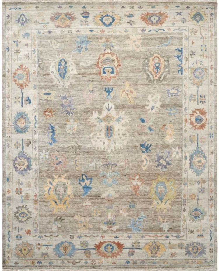 Traditional area rug with a warm oatmeal brown field and scattered floral motifs in blue, terracotta, and ivory, framed by a wide cream border.